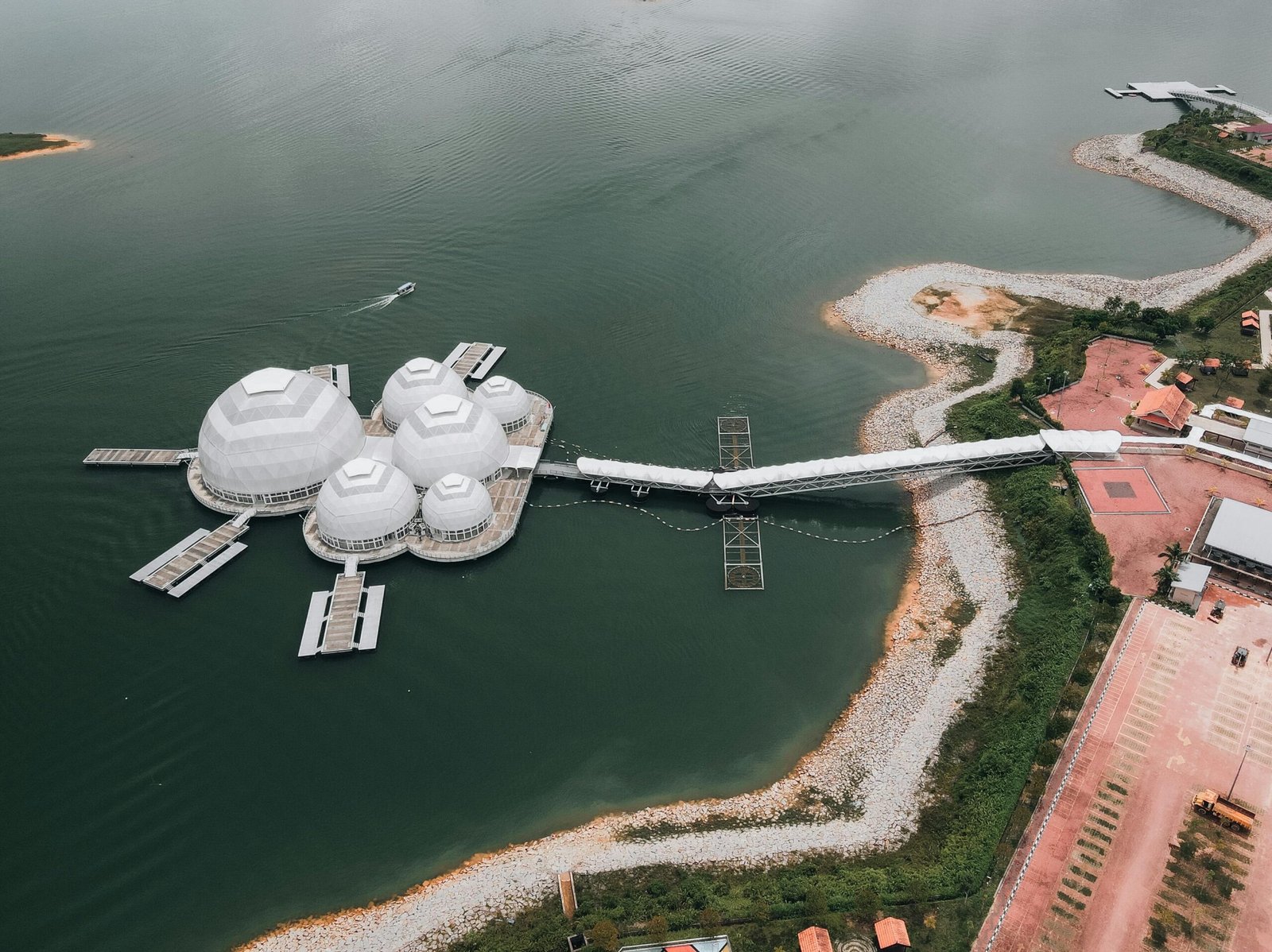 Aerial shot of unique floating structures connected by bridge on tranquil lake.