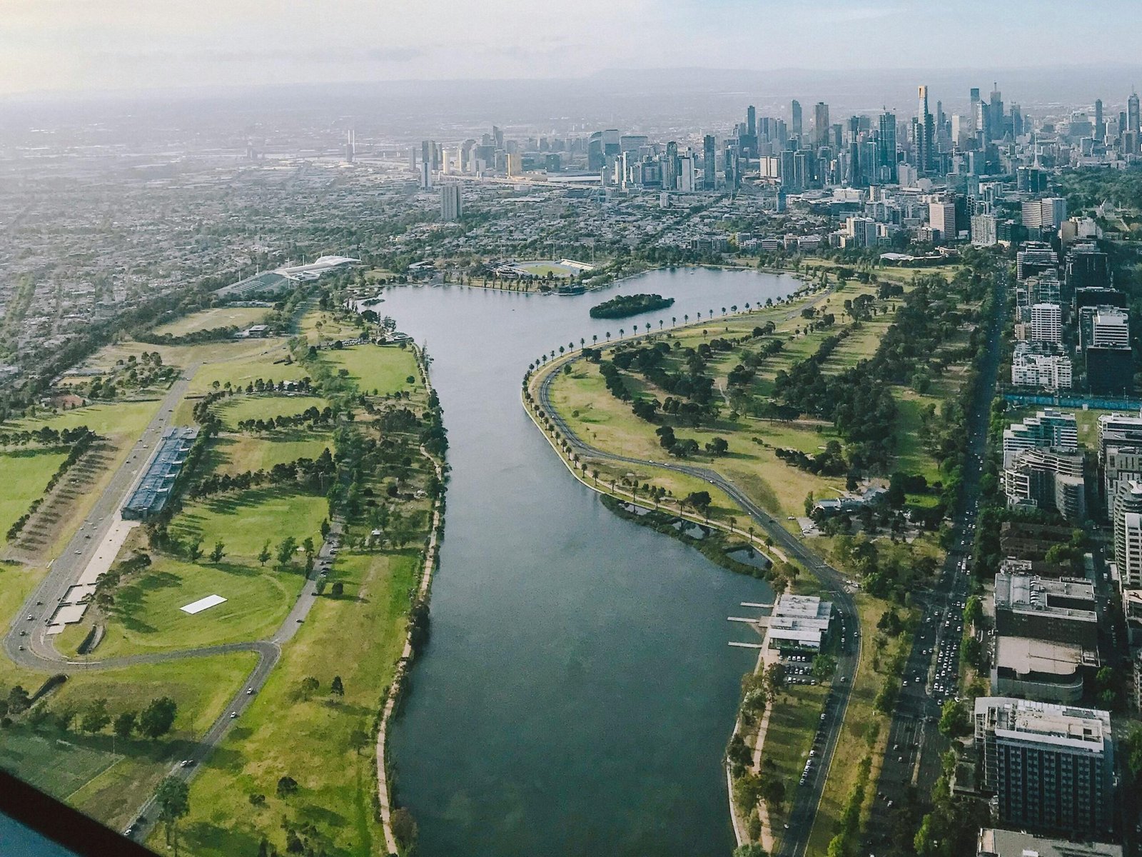 Breathtaking aerial view of Melbourne skyline along the Yarra River with lush greenery.